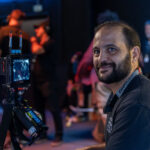 Primeiro assistente de câmera atuando como focus puller em set de filmagem cinema